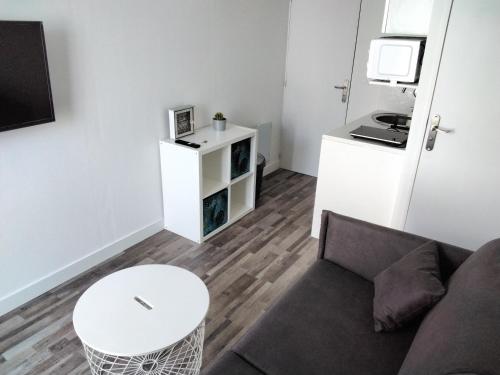 a living room with a couch and a table at Studio indépendant in Fouras