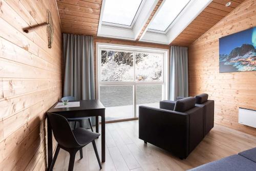 a room with a desk and a chair and a window at Eliassen Rorbuer in Reine
