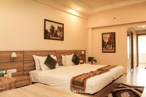 ein Schlafzimmer mit einem großen Bett in einem Zimmer in der Unterkunft Hotel Tea County in Dibrugarh