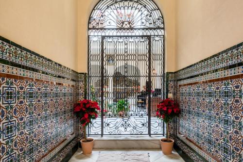 una puerta en un edificio con flores en las paredes en CASA17 Santacruz Suites, en Sevilla