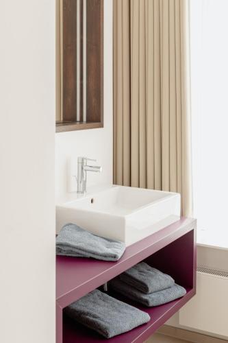 a bathroom with a sink and towels on a shelf at Landgasthof Wagner-Zimmermann in Kinding