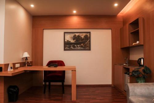 a room with a desk and a painting on the wall at Hotel Tea County in Dibrugarh