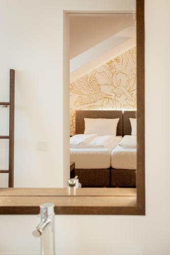 a mirror over a sink with a bed in a room at Landgasthof Wagner-Zimmermann in Kinding