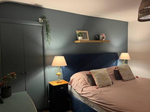 a bedroom with a bed with a blue wall at Lobster Cottage - Stylish 3 Bedroom Cottage in heart of Tenby Town, Pembrokeshire in Pembrokeshire