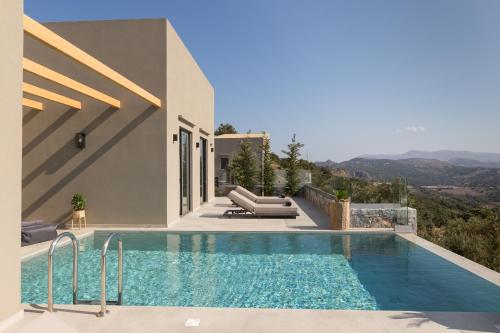 a villa with a swimming pool and a house at Eforasis Villas , an intriguing hideaway, by ThinkVilla in Arménoi