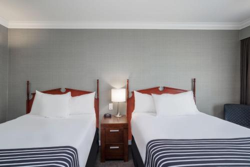 a hotel room with two beds and a chair at Sandman Hotel Revelstoke in Revelstoke