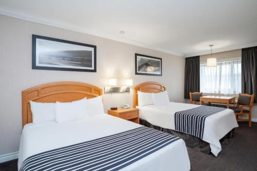um quarto de hotel com duas camas e uma secretária em Sandman Hotel Revelstoke em Revelstoke