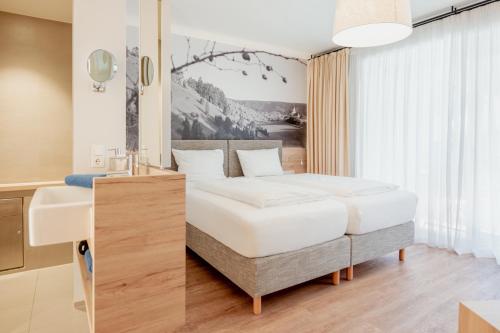 1 dormitorio con cama blanca y escritorio en Landgasthof Wagner, en Kinding