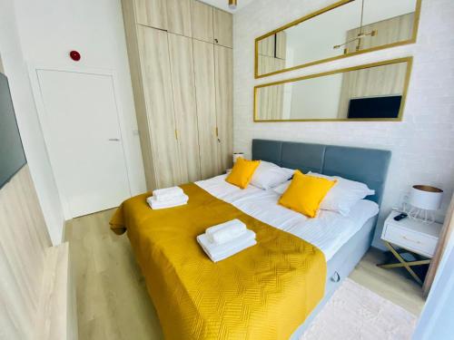 a bedroom with a large bed with yellow pillows at HO!HOUSE SHELLTER ROGOWO in Rogowo