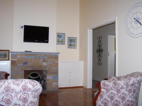 a living room with a fireplace and a tv at RJ's Bed & Breakfast in Maryborough
