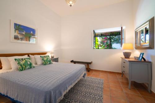 a bedroom with a bed and a desk and a window at Finca Botanico Secret Garden in Guatiza
