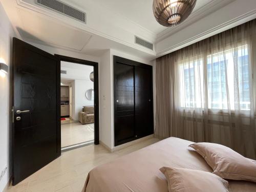 Schlafzimmer mit einem Bett und einer schwarzen Tür in der Unterkunft Bright Flat Lac 2 Tunis in Tunis