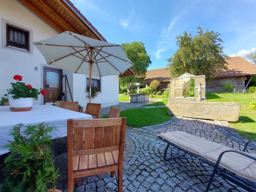 a patio with a table and an umbrella at Ferienwohnungen Anna Altmann in Furth im Wald