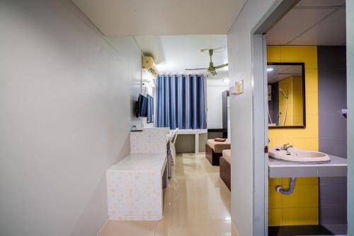a bathroom with a sink and a vanity with a mirror at Pasawang Hotel (โรงแรมภาสว่าง) in Hat Yai