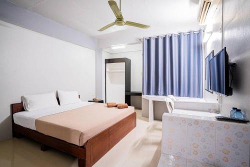a bedroom with a bed and a flat screen tv at Pasawang Hotel (โรงแรมภาสว่าง) in Hat Yai