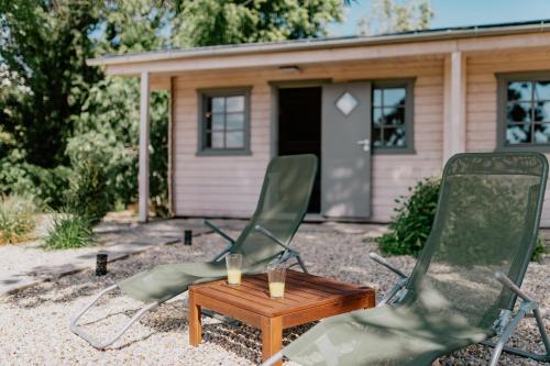 two chairs and a table in front of a house at Zam-zam apartmanok in Zamárdi