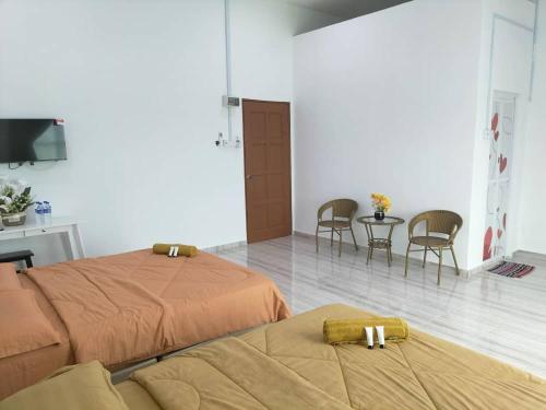 加央的住宿－Kangar Jaya Lodging，卧室配有一张床和一张桌子及椅子
