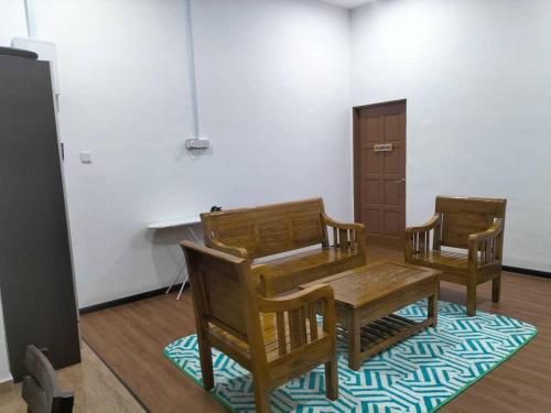 a dining room with a wooden table and two chairs at Kangar Jaya Lodging in Kangar