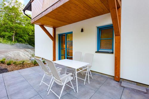 a patio with a white table and white chairs at Hotel Edvard in Frenštát pod Radhoštěm