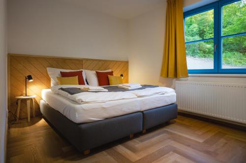 una camera da letto con un grande letto con una grande finestra di Hotel Edvard a Frenštát pod Radhoštěm
