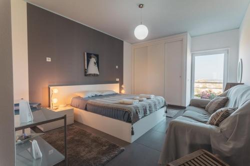 een slaapkamer met een bed en een bank bij Best Houses 38 - Praia Residences in Peniche