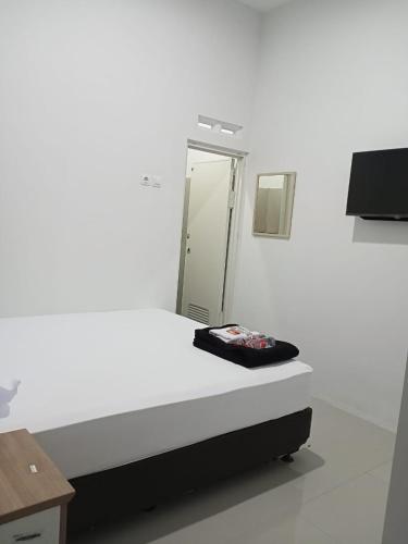 a white room with a mirror and a bed at Srikandi Baru Inn Blok O in Bantul