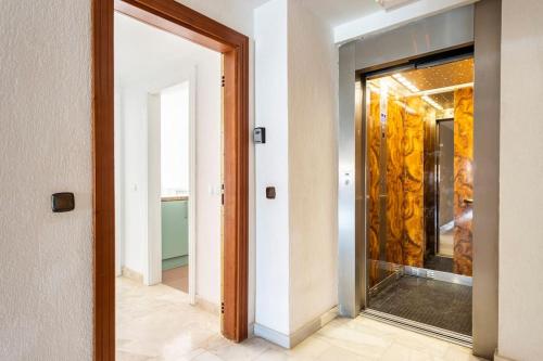 un couloir avec une porte vitrée donnant sur une pièce dans l'établissement Apartamento en Los Cristianos urb.Playa Graciosa, à Los Cristianos