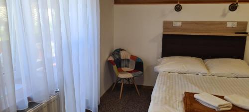 a bedroom with a bed and a chair next to a window at "Hel" Wieniec Zdrój in Włocławek