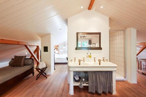 a bathroom with a sink and a bed in a room at Boutique-Hotel Schlüssel in Beckenried