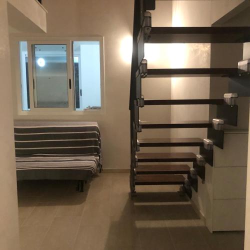 a room with a staircase with a window and a bench at La Caletta di Afrodite in Calabernardo
