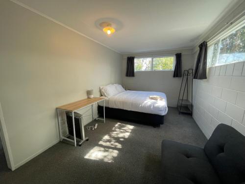 a bedroom with a bed and a desk and window at Private 2 bedrooms suite with free parking in Rotorua