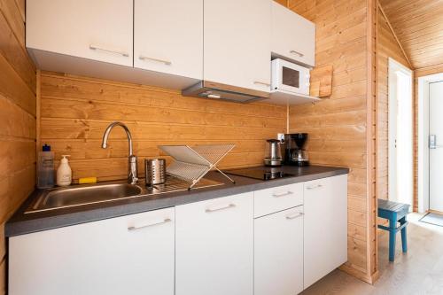 a kitchen with white cabinets and a sink at Eliassen Rorbuer in Reine