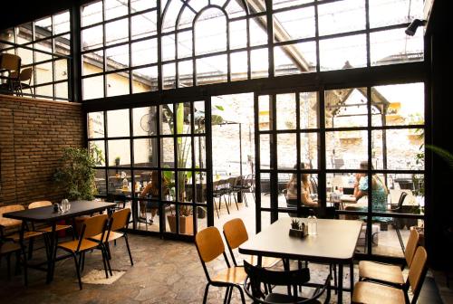 een restaurant met tafels en stoelen en een groot raam bij Exis Suite in Athene