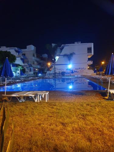 un grande edificio bianco di notte con luci blu di Résidence SUN SET BEACH à 200 m de mer a Mohammedia