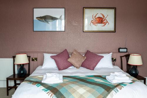 um quarto com uma cama com três fotografias na parede em Three Tuns em Helston