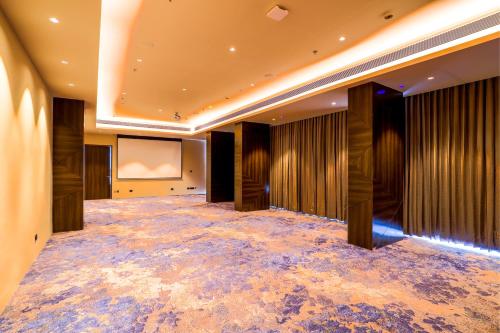 a large room with a projection screen and a stage at 7 Apple Hotel Jal Mahal, Jaipur in Jaipur