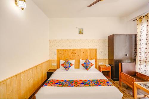 a bedroom with a bed with a wooden headboard at FabHotel The Countryside B and B in Manāli
