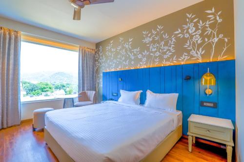 a bedroom with a large bed with a blue wall at 7 Apple Hotel Jal Mahal, Jaipur in Jaipur