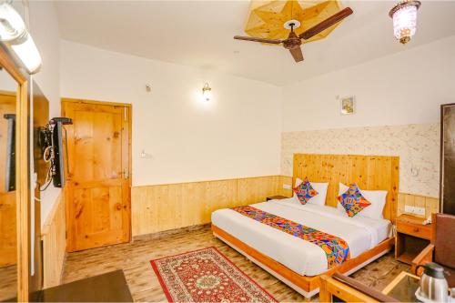 a bedroom with a bed and a ceiling fan at FabHotel The Countryside B and B in Manāli