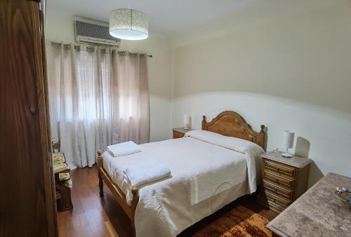 1 dormitorio con 1 cama grande con sábanas blancas en Apartamento Mondego, en Penacova