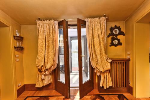 ein Raum mit einer Glastür mit Vorhängen in der Unterkunft San Marco Elegante Panoramico Esclusivo 2 bagni in Venedig