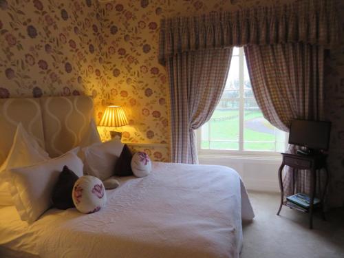 a bedroom with a bed with pillows and a window at Tankardstown House in Slane