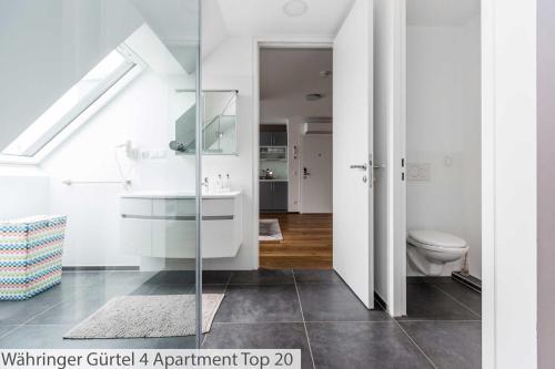 a white bathroom with a toilet and a sink at Flarent Vienna Apartments-WG in Vienna