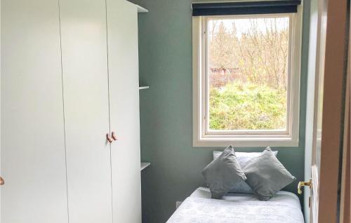 um quarto com uma janela e uma cama com almofadas em Lovely Home In Frjestaden With Wifi em Färjestaden