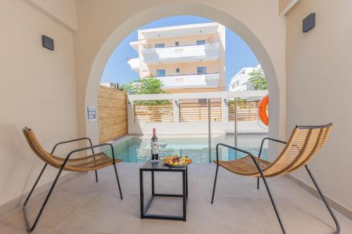 a room with two chairs and a table and a pool at Cabana Blu Hotel & Suites in Kardamaina