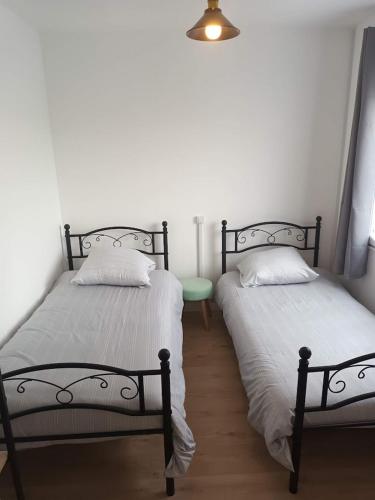two beds sitting next to each other in a room at La charmante Cayolaise in Cayeux-sur-Mer