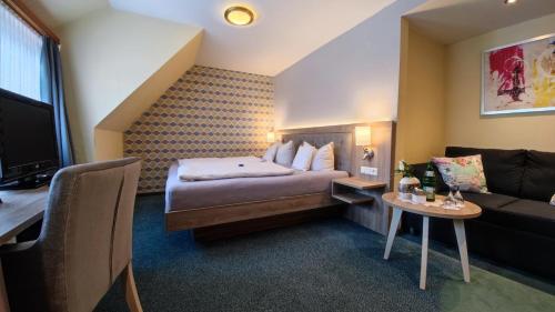 a hotel room with a bed and a couch at Hotel Garni "Zur Alten Post" in Willingen