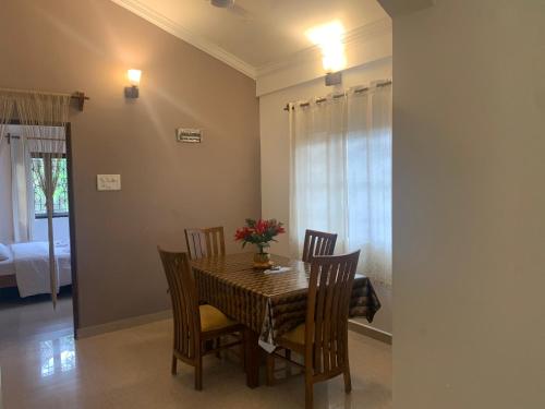 a dining room with a table and chairs and a bedroom at Casa Margarida in Calangute