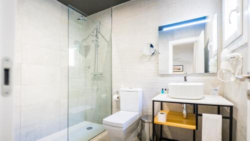 a bathroom with a toilet and a sink and a shower at Moon Hotel & SPA. in Aguadulce