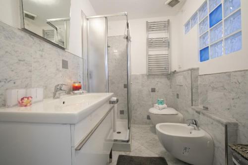 a bathroom with a sink and a shower and a toilet at Appartamento Giulia - Alassio in Alassio